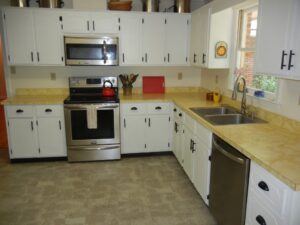 Kitchen with white cabinets and yellow counters