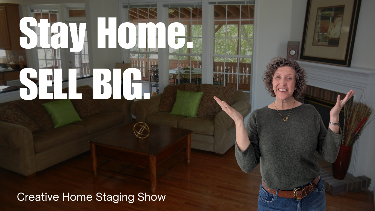 Kasia McDaniel, host of Creative Home Staging Show, is wearing a blue sweater with her hands by her head as if hiding. The background shows a teal painted dining room.