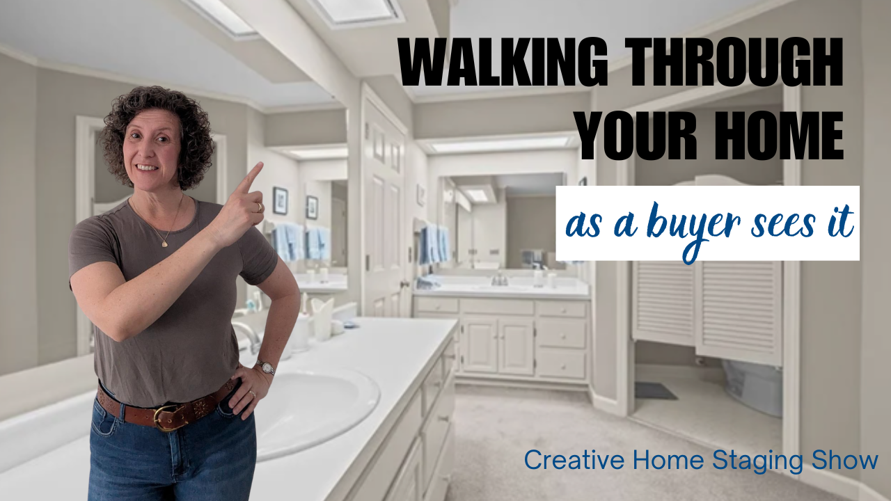 Kasia McDaniel, host of Creative Home Staging Show, is wearing a blue sweater with her hands by her head as if hiding. The background shows a teal painted dining room.