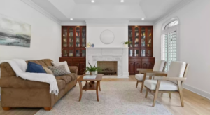 staged living room with couch facing 2 white chairs, coffee table, throw pillows, artwork and no toys