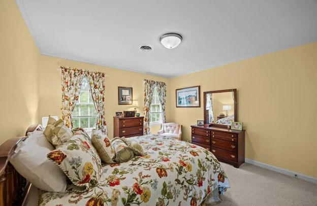 yellow bedroom with busy flower bedding and matching curtains